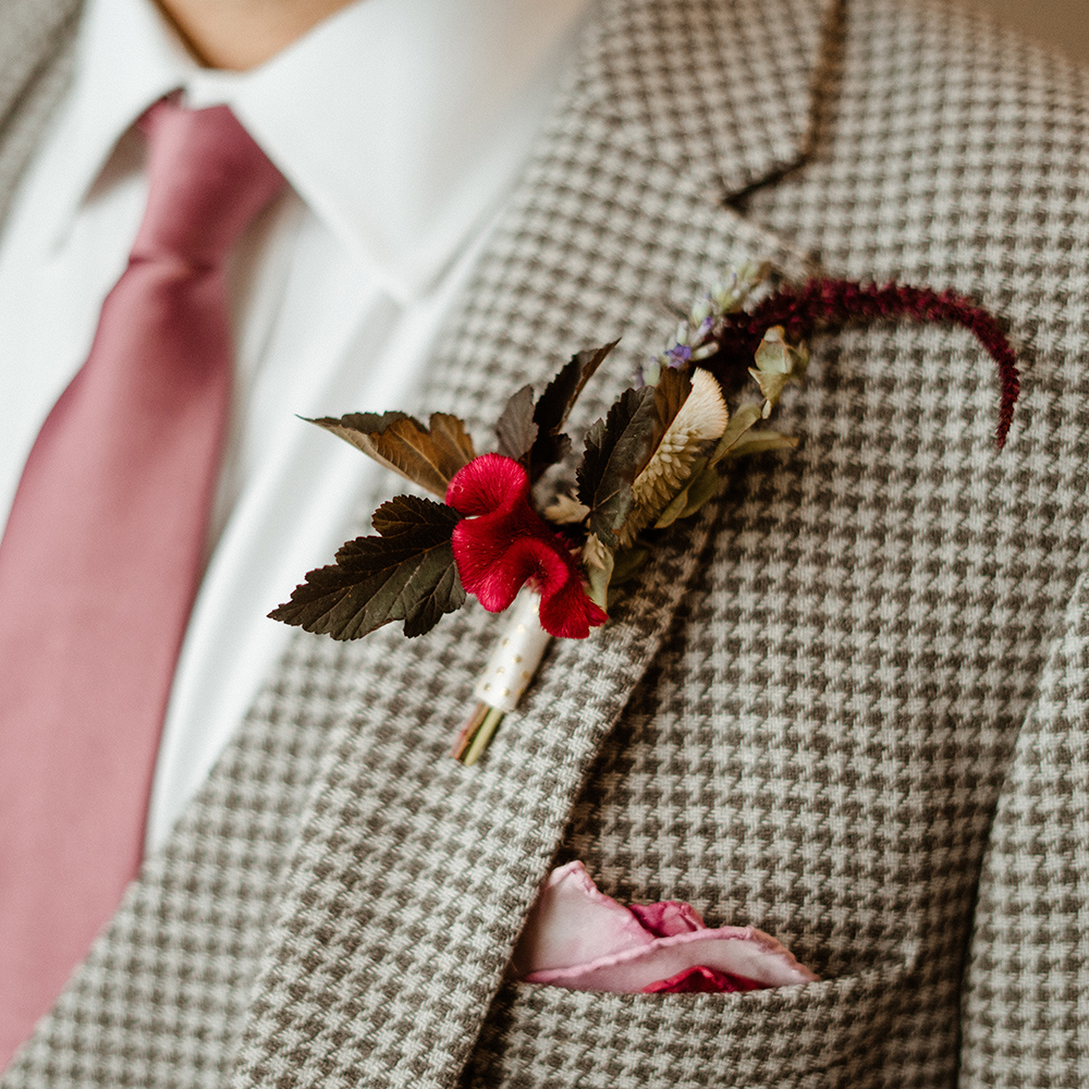 bride holding bouquet of pale roses and dark red berries